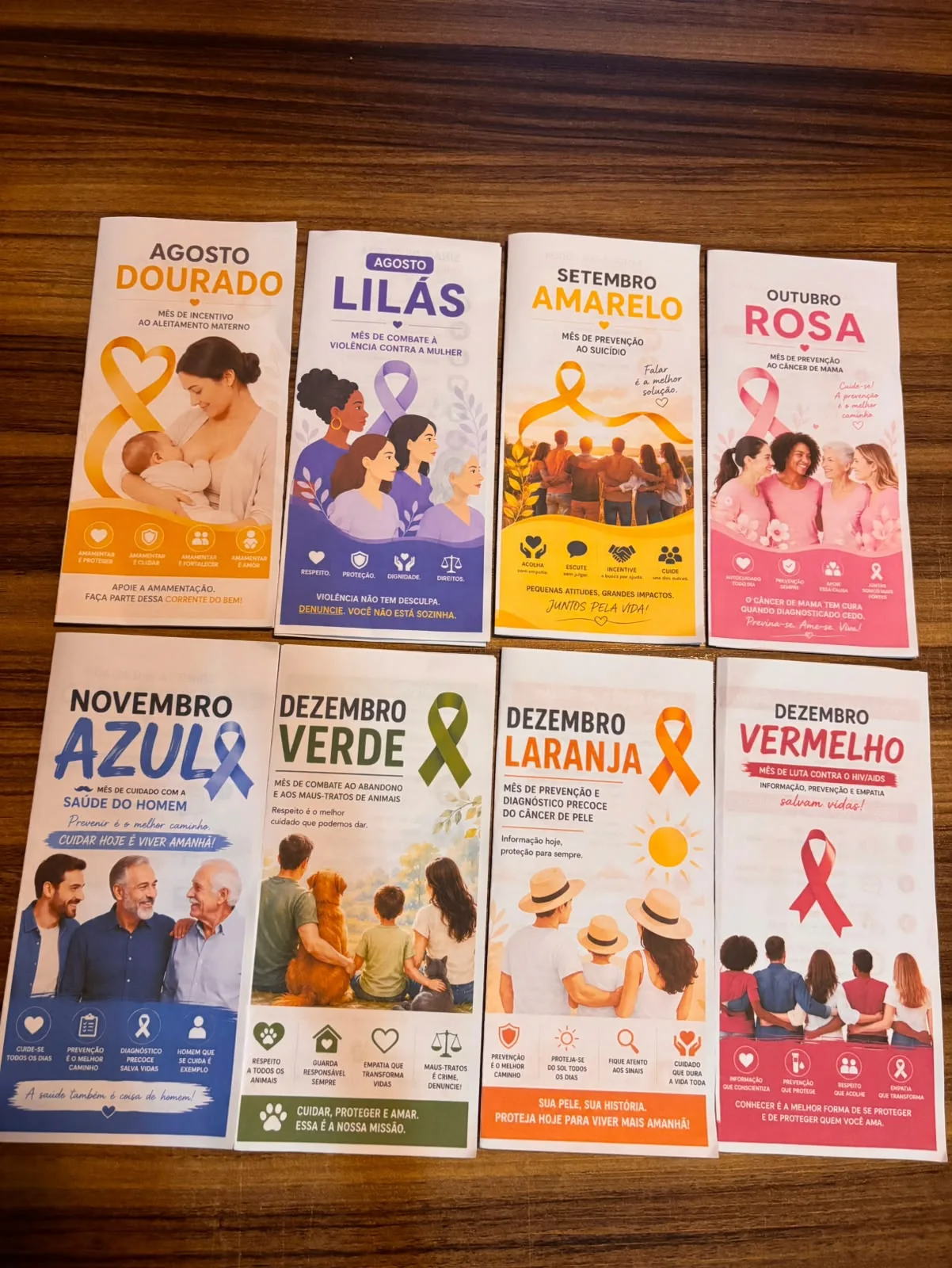 Os 8 folders do combo impressos, dispostos lado a lado sobre uma mesa