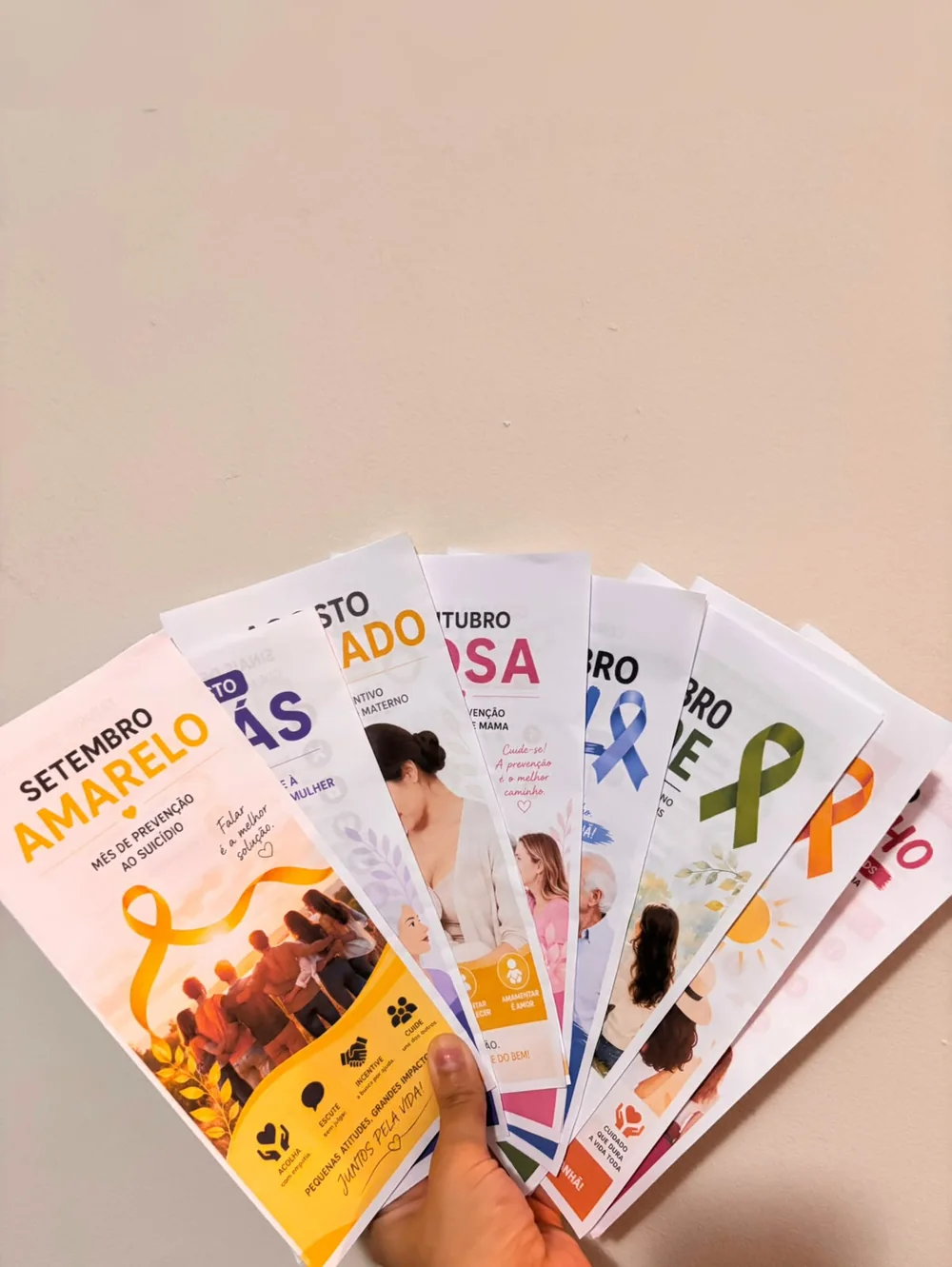 Folders impressos segurados em leque, com o Setembro Amarelo à frente